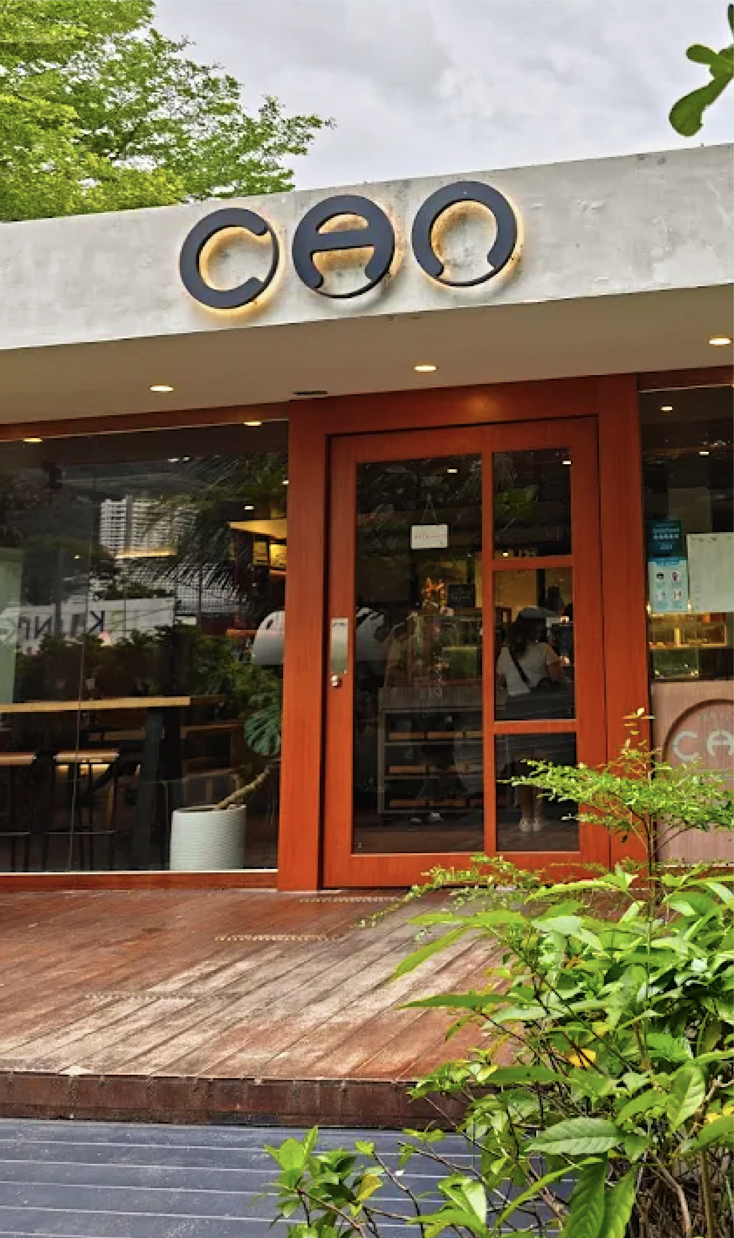 The wooden-decked storefront of Project CAN with bronze CAO signage.